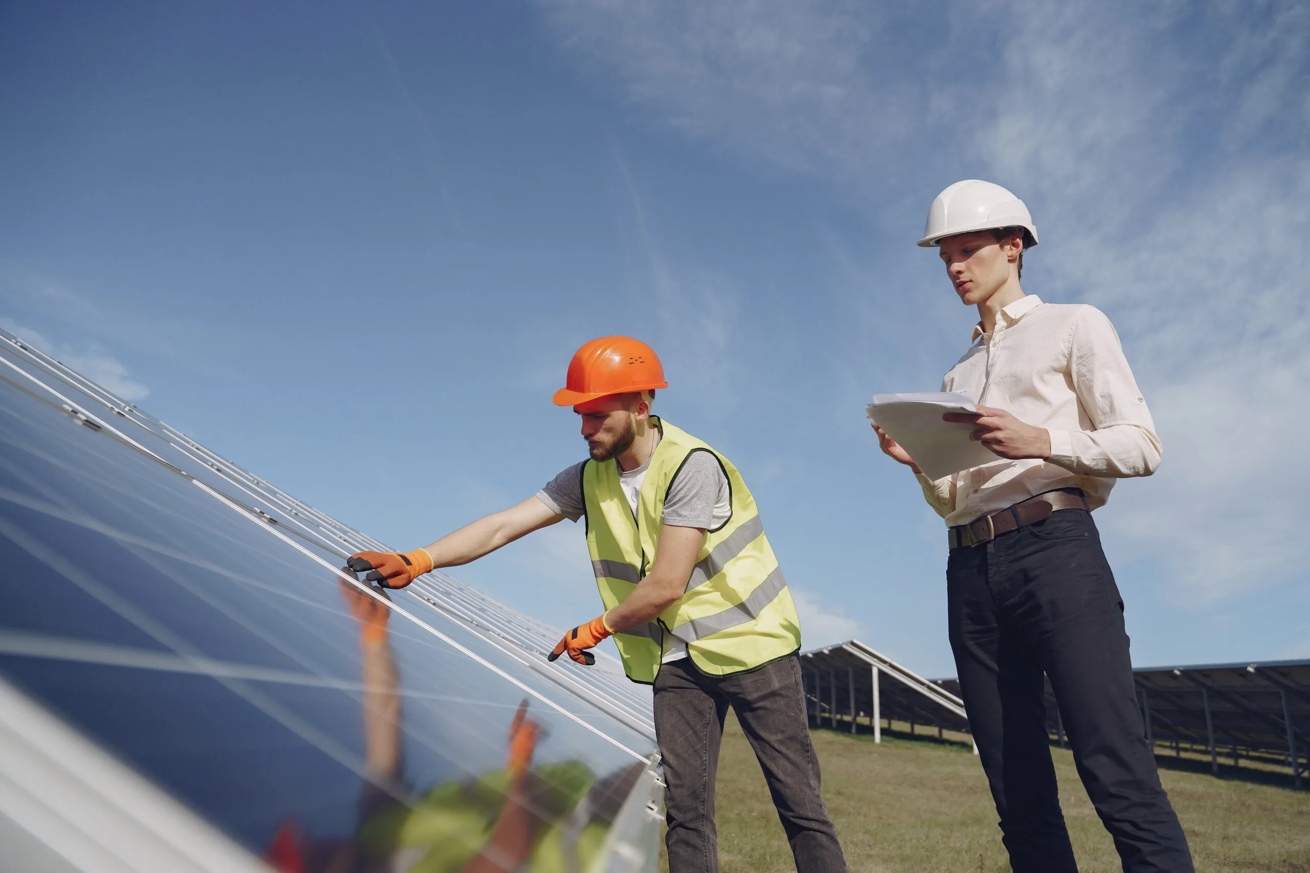 Businessman and worker near solar energy batteries. Business client showing photovoltaic detail to foreman. Two men making deal.